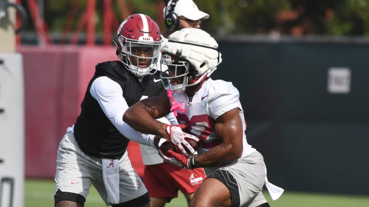 The Crimson Tide works out on the first day of practice for the 2024 season Wednesday, July 31, 2024. Alabama quarterback Jalen Milroe (4) hands the ball off to Alabama running back Justice Haynes (22).