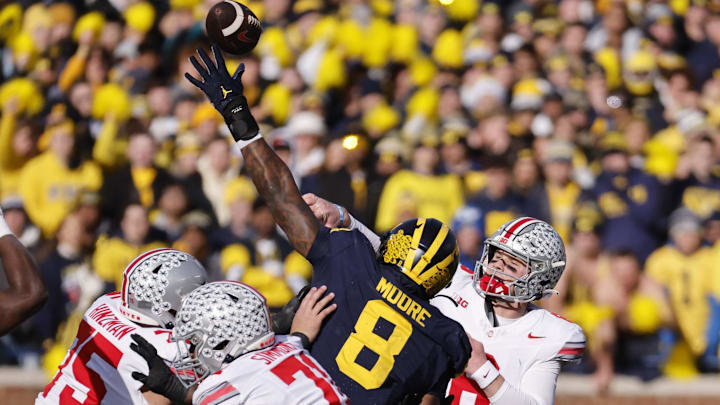 Nov 25, 2023; Ann Arbor, Michigan, USA; Ohio State Buckeyes quarterback Kyle McCord (6) passes under pressure from Michigan Wolverines defensive end Derrick Moore (8) in the first half at Michigan Stadium. Mandatory Credit: Rick Osentoski-Imagn Images