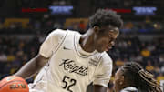 Mar 8, 2025; Morgantown, West Virginia, USA; UCF Knights center Moustapha Thiam (52) makes a move against West Virginia Mountaineers guard Javon Small (7) during the second half at WVU Coliseum. Mandatory Credit: Ben Queen-Imagn Images