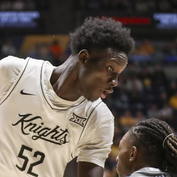 Mar 8, 2025; Morgantown, West Virginia, USA; UCF Knights center Moustapha Thiam (52) makes a move against West Virginia Mountaineers guard Javon Small (7) during the second half at WVU Coliseum. Mandatory Credit: Ben Queen-Imagn Images