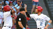 Angels catcher Martin Maldonado (12) and shortstop Andrelton Simmons (2) both scored on a single by second baseman Danny Espinosa (3) singles in two runs in the fifth inning against the Kansas City Royals at Angel Stadium of Anaheim.