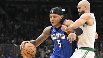 Jan 17, 2025; Boston, Massachusetts, USA; Orlando Magic forward Paolo Banchero (5) dribbles the ball against Boston Celtics guard Derrick White (9) during the first half at TD Garden. Mandatory Credit: Eric Canha-Imagn Images