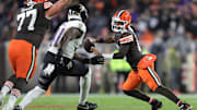 Cleveland Browns quarterback Shedeur Sanders (12) tries to get away from Baltimore Ravens defensive end Dre'Mont Jones (41) during the second half of an NFL football game at Huntington Bank Field, Nov. 16, 2025, in Cleveland, Ohio.