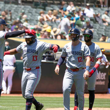 Minnesota Twins right fielder Manuel Margot (13) gets a hug from Carlos Correa (4) after hitting a three-run home run against the Oakland Athletics during the second inning at Oakland-Alameda County Coliseum in Oakland, Calif., on June 22, 2024. 