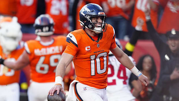 Bo Nix holds the ball and smiles after a score.