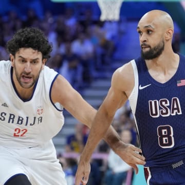 Jul 28, 2024; Villeneuve-d'Ascq, France; United States guard Derrick White (8) drives against Serbia point guard Vasilije Micic (22) in the second quarter during the Paris 2024 Olympic Summer Games at Stade Pierre-Mauroy. Mandatory Credit: John David Mercer-USA TODAY Sports