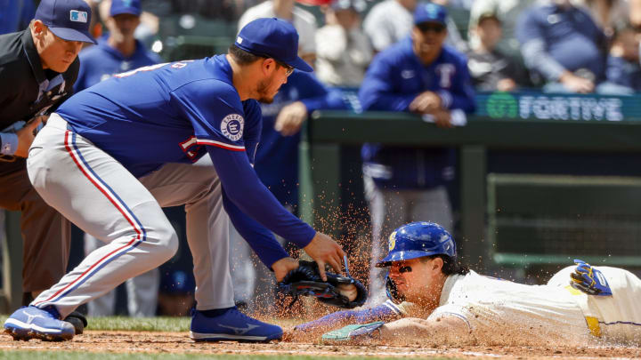 Seattle Mariners third baseman Josh Rojas (4) slides to score a run on a wild pitch by Texas Rangers starting pitcher Dane Dunning (33) during the fifth inning at T-Mobile Park on June 17.