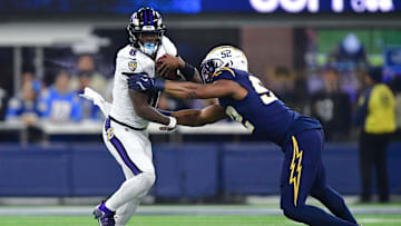 Nov 25, 2024; Inglewood, California, USA; Baltimore Ravens quarterback Lamar Jackson (8) runs the ball against Los Angeles Chargers linebacker Khalil Mack (52) during the second half at SoFi Stadium. Mandatory Credit: Gary A. Vasquez-Imagn Images