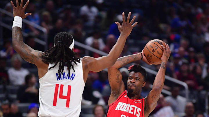 Apr 14, 2024; Los Angeles, California, USA; Houston Rockets forward Reggie Bullock Jr. (25) controls the ball against Los Angeles Clippers guard Terance Mann (14) during the first half at Crypto.com Arena. Mandatory Credit: Gary A. Vasquez-Imagn Images