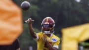 Jul 25, 2024; Ashburn, VA, USA; Washington Commanders quarterback Jayden Daniels (5) passes a ball during drills on day two of Commanders training camp at OrthoVirginia Training Center at Commanders Park. Mandatory Credit: Geoff Burke-USA TODAY Sports