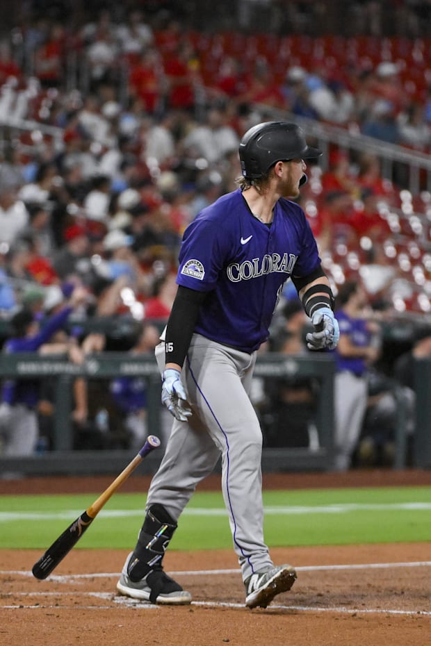 Goodman in grey pants and a purple jersey looking off after he hit a two run homer against the cardinals with a black ba