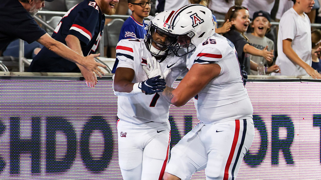 Aug 31, 2024; Tucson, Arizona, USA; Arizona Wildcats running back Jacory Croskey-Merritt (1) celebrates a touchdown with fans and Arizona Wildcats offensive lineman Leif Magnuson during the fourth quarter at Arizona Stadium.