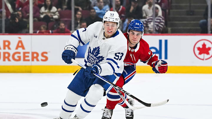 Sep 30, 2023; Montreal, Quebec, CAN; Toronto Maple Leafs right wing Easton Cowan (53) plays the puck against Montreal Canadiens left wing Juraj Slafkovsky (20) during the first period at Bell Centre. Mandatory Credit: David Kirouac-Imagn Images