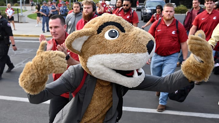 Sep 7, 2024; Pullman, Washington, USA; Washington State Cougars mascot Butch (right) and Washington State Cougars head coach Jake Dickert lead the football team into Gesa Field at Martin Stadium for a game against the Texas Tech Red Raiders. Mandatory Credit: James Snook-Imagn Images