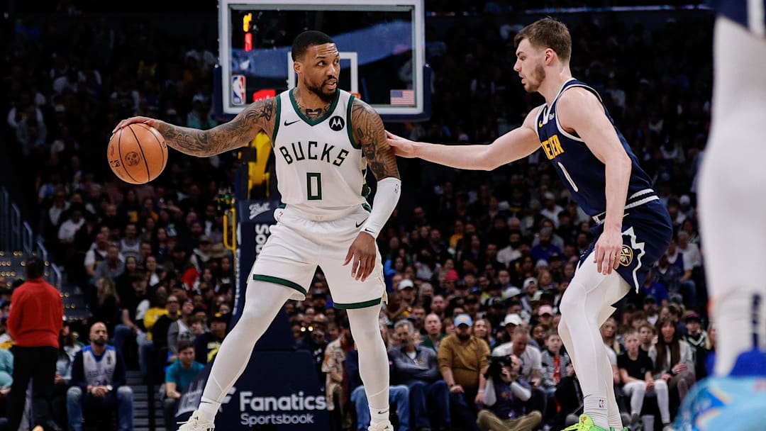 Jan 29, 2024; Denver, Colorado, USA; Milwaukee Bucks guard Damian Lillard (0) controls the ball as Denver Nuggets guard Christian Braun (0) guards in the second quarter at Ball Arena. Mandatory Credit: Isaiah J. Downing-Imagn Images