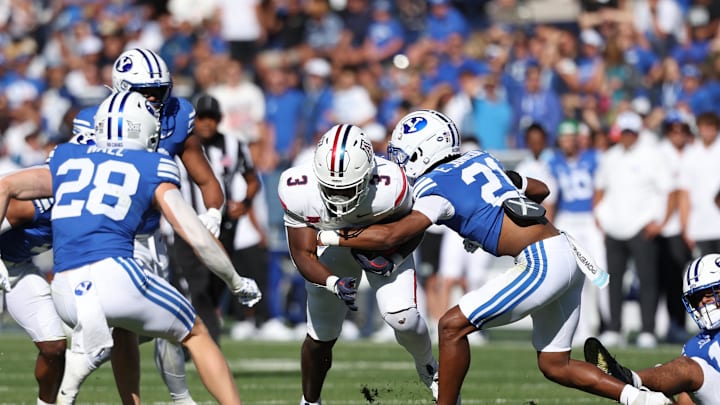 Oct 12, 2024; Provo, Utah, USA; Arizona Wildcats running back Kedrick Reescano (3) is tackled by Brigham Young Cougars cornerback Evan Johnson (21) during the second quarter at LaVell Edwards Stadium. Mandatory Credit: Rob Gray-Imagn Images