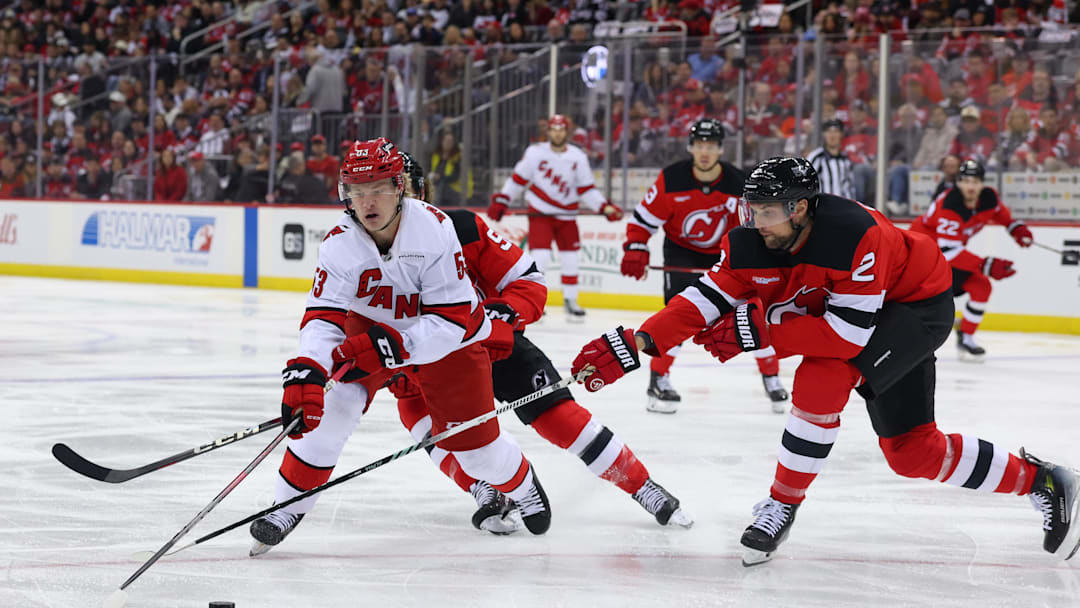 Apr 27, 2025; Newark, New Jersey, USA; Carolina Hurricanes right wing Jackson Blake (53) skates with the puck as New Jersey Devils defenseman Brian Dumoulin (2) defends during the first period in game four of the first round of the 2025 Stanley Cup Playoffs at Prudential Center. Mandatory Credit: Ed Mulholland-Imagn Images