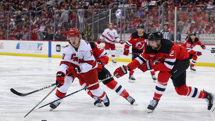 Apr 27, 2025; Newark, New Jersey, USA; Carolina Hurricanes right wing Jackson Blake (53) skates with the puck as New Jersey Devils defenseman Brian Dumoulin (2) defends during the first period in game four of the first round of the 2025 Stanley Cup Playoffs at Prudential Center. Mandatory Credit: Ed Mulholland-Imagn Images