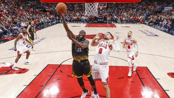 Jan 15, 2023; Chicago, Illinois, USA; Golden State Warriors forward Draymond Green (23) goes to the basket against Chicago Bulls center Nikola Vucevic (9) during the second half of an NBA game at United Center. 