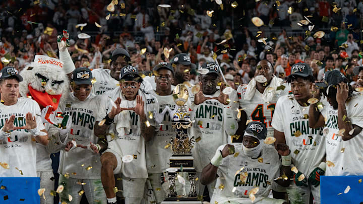Miami fans celebrate with the Fiesta Bowl Trophy after winning the CFP Fiesta Bowl against Ole Miss.