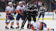 Apr 13, 2025; Newark, New Jersey, USA; New York Islanders defenseman Adam Pelech (3) lies on the ice after being hit in the head by New Jersey Devils center Paul Cotter (47) during the second period at Prudential Center. Mandatory Credit: Ed Mulholland-Imagn Images