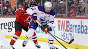 Mar 13, 2025; Newark, New Jersey, USA; Edmonton Oilers center Leon Draisaitl (29) skates with the puck as New Jersey Devils defenseman Simon Nemec (17) defends during the first period at Prudential Center. Mandatory Credit: Ed Mulholland-Imagn Images
