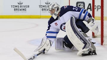 Mar 7, 2025; Newark, New Jersey, USA; Winnipeg Jets goaltender Connor Hellebuyck (37) plays the puck against the New Jersey Devils during the second period at Prudential Center. Mandatory Credit: Ed Mulholland-Imagn Images