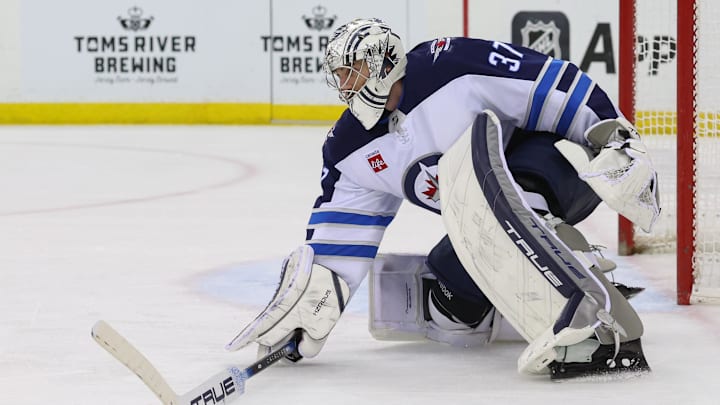 Mar 7, 2025; Newark, New Jersey, USA; Winnipeg Jets goaltender Connor Hellebuyck (37) plays the puck against the New Jersey Devils during the second period at Prudential Center. Mandatory Credit: Ed Mulholland-Imagn Images