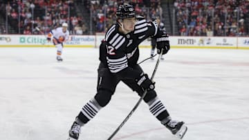 Apr 13, 2025; Newark, New Jersey, USA; New Jersey Devils center Cody Glass (12) shoots the puck against the New York Islanders during the second period at Prudential Center. Mandatory Credit: Ed Mulholland-Imagn Images
