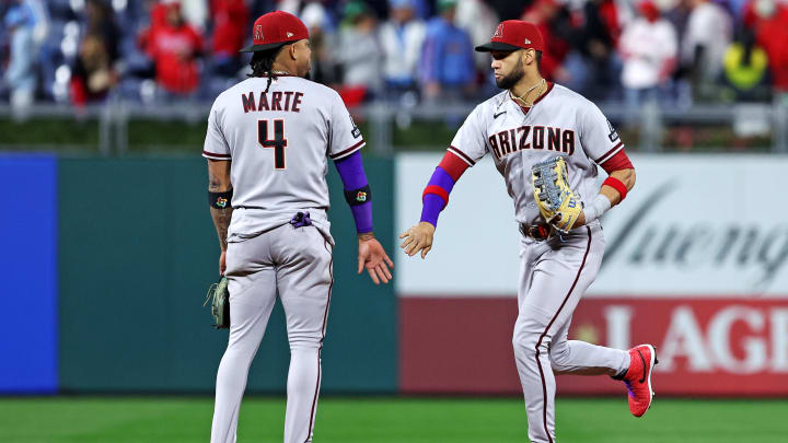 Oct 23, 2023; Philadelphia, Pennsylvania, USA; Arizona Diamondbacks second baseman Ketel Marte (4) celebrates with left fielder Lourdes Gurriel Jr. (12) after beating the Philadelphia Phillies in game six of the NLCS for the 2023 MLB playoffs at Citizens Bank Park. Mandatory Credit: Bill Streicher-USA TODAY Sports