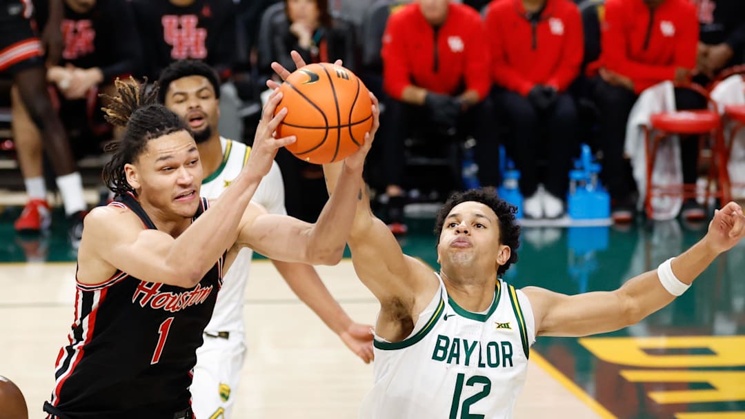 Jan 10, 2026; Waco, Texas, USA; Houston Cougars guard Isiah Harwell (1) grabs a rebound against Baylor Bears guard Michael Rataj (12) during the second half at Paul and Alejandra Foster Pavilion. Mandatory Credit: Chris Jones-Imagn Images