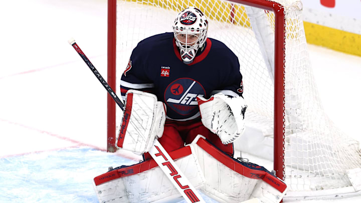 Mar 28, 2025; Winnipeg, Manitoba, CAN; Winnipeg Jets goaltender Connor Hellebuyck (37) eyes an incoming shot from the New Jersey Devils in the third period at Canada Life Centre. Mandatory Credit: James Carey Lauder-Imagn Images