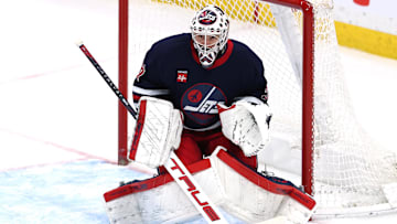 Winnipeg Jets goaltender Connor Hellebuyck (37) eyes an incoming shot from the New Jersey Devils.