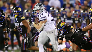 Kansas State junior tight end Ben Sinnott (34) drives through Kansas defenders during the first quarter of Saturday's Sunflower Showdown against Kansas inside David Booth Kansas Memorial Stadium.