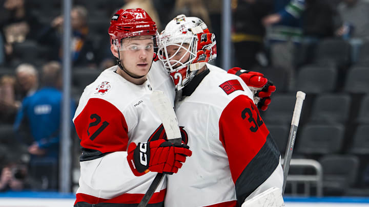 Mar 4, 2026; Vancouver, British Columbia, CAN; Carolina Hurricanes defenseman Alexander Nikishin (21) and goalie Brandon Bussi (32) celebrate their victory against the Vancouver Canucks at Rogers Arena. Mandatory Credit: Bob Frid-Imagn Images