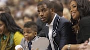Mar 2, 2013; Winston Salem, NC, USA; Los Angeles Clippers player Chris Paul sits with his son Christopher Paul and wife Jada Paul during the first half of the game between the Wake Forest Demon Deacons and the Maryland Terrapins at Lawrence Joel Veterans Memorial Coliseum. Mandatory Credit: Jeremy Brevard-Imagn Images