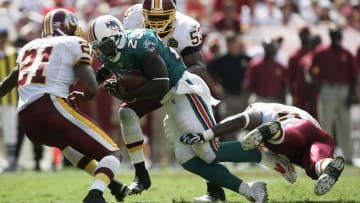 Sept 9, 2007; Landover, MD, USA; Miami Dolphins running back Ronnie Brown (23) carries the ball as he is tackled by Washington Redskins safety Sean Taylor (21), linebacker Marcus Washington (53) and linebacker Rocky McIntosh (52) in the second quarter at FedEx Field in Landover, MD.  Washington defeated Miami 16-13.  Mandatory Credit: James Lang-USA TODAY Sports Copyright © James Lang