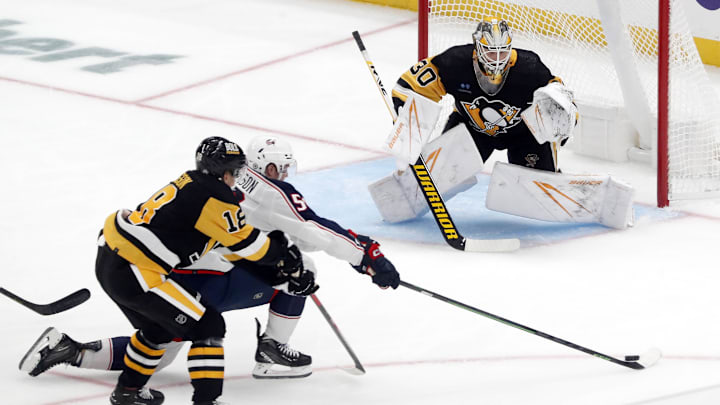 Sep 24, 2023; Pittsburgh, Pennsylvania, USA; Pittsburgh Penguins left wing Andreas Johnsson (18) commits a hooking penalty against Columbus Blue Jackets left wing Eric Robinson (50) in front of Penguins goaltender Joel Blomqvist (30) during the second period at PPG Paints Arena. Mandatory Credit: Charles LeClaire-Imagn Images