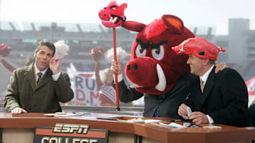 Lee Corso picks the Razorbacks to win the Arkansas/Tennessee game as Chris Fowler, left, and Kirk Herbstreit, right, end the show. ESPN College GameDay is a weekly television program that airs during the college football season. The hosts are Kirk Herbstreit, Lee Corso, and Chris Fowler. The production was in Fayetteville, Arkansas Nov. 12 for the Arkansas/Tennessee game.