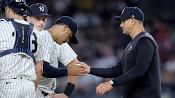 New York Yankees manager Aaron Boone (17) takes the ball from relief pitcher Fernando Cruz (63)