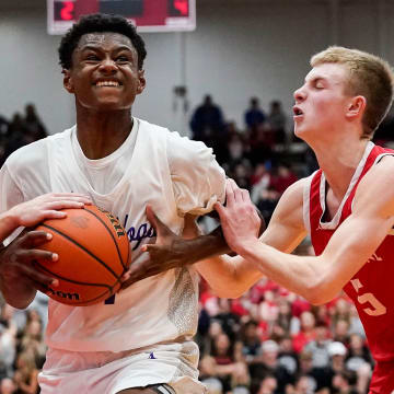 Brownsburg Bulldogs forward Kanon Catchings (14) rushes up the court against New Palestine Dragons Ian Stephens (5) on Saturday, March 11, 2023 at Southport High School in Indianapolis. The Brownsburg Bulldogs defeated the New Palestine Dragons, 66-39, for the IHSAA Class 4A regional championship.

High School Basketball Ini Hs Basketball Southport Regional