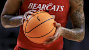 Jan 1, 2022; Cincinnati, Ohio, USA;  The Cincinnati logo is seen on an official game ball as Cincinnati Bearcats guard Jeremiah Davenport (24) attempts a free throw against the Tulane Green Wave in the second half at Fifth Third Arena. Mandatory Credit: Aaron Doster-Imagn Images