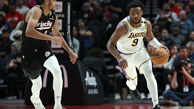 Apr 13, 2025; Portland, Oregon, USA; Los Angeles Lakers guard Bronny James (9) brings the ball up the court past Portland Tra