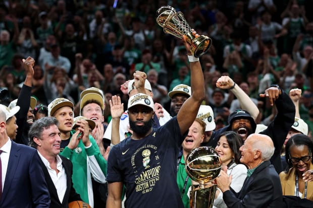 Boston Celtics guard Jaylen Brown raises the NBA Finals MVP Trophy after winning the 2024 NBA championship.