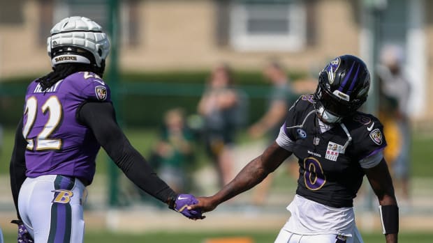 Baltimore Ravens quarterback Lamar Jackson (8) slaps hands with running back Derrick Henry (22) during a joint practice with 