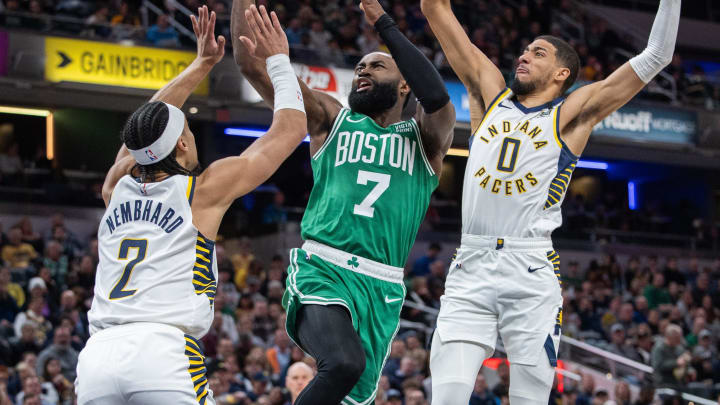 Jan 8, 2024; Indianapolis, Indiana, USA; Boston Celtics guard Jaylen Brown (7) shoots the ball while Indiana Pacers guard Andrew Nembhard (2) and guard Tyrese Haliburton (0)  defend in the first half at Gainbridge Fieldhouse. Mandatory Credit: Trevor Ruszkowski-USA TODAY Sports
