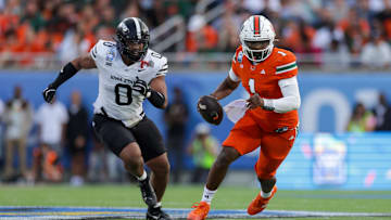Dec 28, 2024; Orlando, FL, USA; Miami Hurricanes quarterback Cam Ward (1) runs with the ball against the Iowa State Cyclones in the second quarter during the Pop Tarts bowl at Camping World Stadium. Mandatory Credit: Nathan Ray Seebeck-Imagn Images