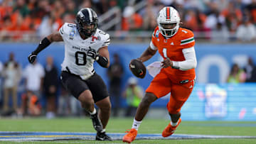 Dec 28, 2024; Orlando, FL, USA; Miami Hurricanes quarterback Cam Ward (1) runs with the ball against the Iowa State Cyclones in the second quarter during the Pop Tarts bowl at Camping World Stadium. Mandatory Credit: Nathan Ray Seebeck-Imagn Images