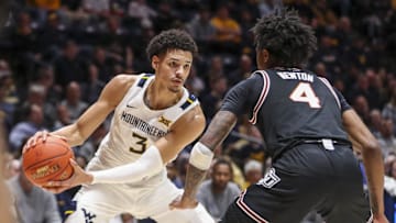 Feb 20, 2023; Morgantown, West Virginia, USA; West Virginia Mountaineers forward Tre Mitchell (3) controls the ball against Oklahoma State Cowboys guard Woody Newton (4) during the second half at WVU Coliseum. Mandatory Credit: Ben Queen-Imagn Images