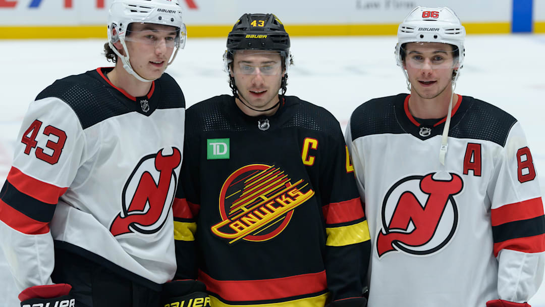 Brothers Luke (left), Quinn (center), and Jack (right) Hughes pose for a photo before a contest between the New Jersey Devils and Vancouver Canucks.